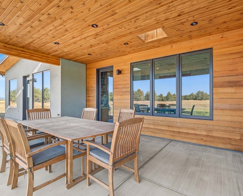 modern large covered porch with cedar walls and ceiling and tile floor for easy outdoor living and entertaining