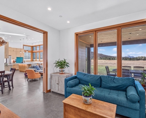 vaulted and bright living room with floor to ceiling windows
